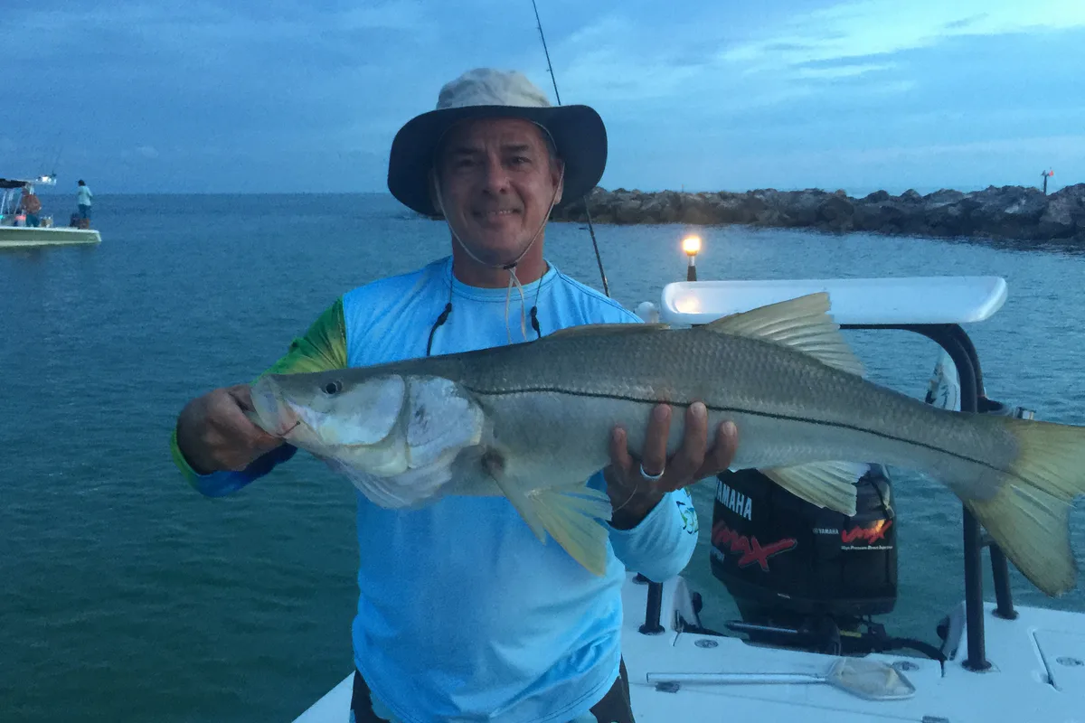 Angler on a boat off Clearwater holding a big common snook