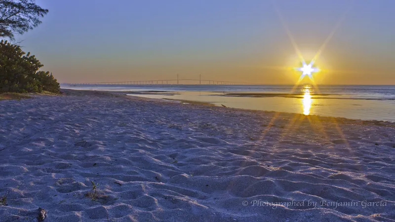 Sunrise over Tampa Bay from a Fort De Soto beach, Skyway Bridge in the distance